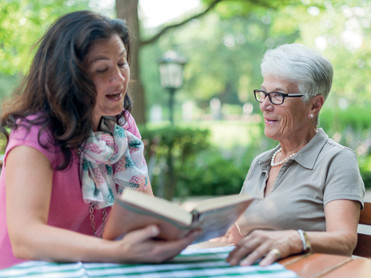 Abseits von Pflege und Hausarbeit hat die Senioren-Assistentin auch Zeit, gemeinsam in einem Buch zu schmökern. Foto: Martin Hänisch/akz-o