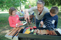 Bildunterschrift: Glühende Kohlen und der unwiderstehliche Duft brutzelnder Würstchen: Besonders Familien nutzen die warme Jahreszeit, um zusammen zu grillen. Foto: goodluz/stock.adobe.com/akz-o