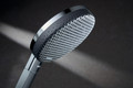 Bildunterschrift: Strahlscheibe oder Lautsprecher? Durch das fast stofflich wirkende, neuartige Mesh-Design aus elegantem, eloxiertem Aluminium wirken hansgrohe Raindance Alive Kopfbrausen homogener und weniger technisch. Foto: hansgrohe/Hansgrohe SE/akz-o