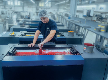 Präzisionsarbeit: Azubi Marijan Denkovski gibt Farbe in die Druckmaschine ein. Foto: colordruck/akz-o
