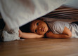 Bildunterschrift: Bei einem Brand reagieren Kinder häufig nicht mit Flucht, sondern verstecken sich zum Beispielunter dem Bett. Deswegen ist es wichtig, dass die Eltern so früh wie möglich alarmiert werden. Foto: Ei Electronics/iStock/Borovikk/akz-o
